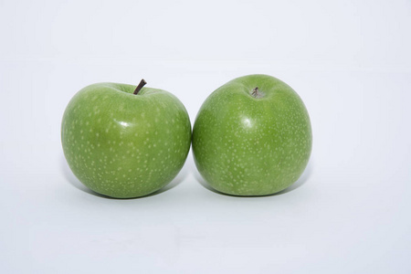 在白色背景上有两个美味而闪亮的绿色苹果