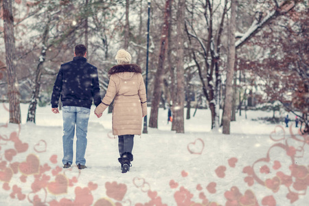 情人节假期年轻漂亮的夫妇在冬季公园散步