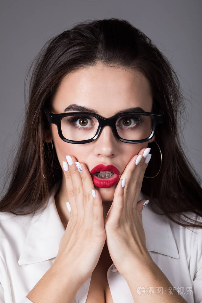 一个性感的黑发女人的肖像在眼镜与惊讶的表情