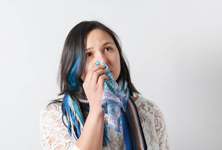 特写美女打喷嚏和咳嗽的肖像，用摩擦鼻子有重感冒隔离在白色背景上。 绝望的女人患感冒，流鼻涕