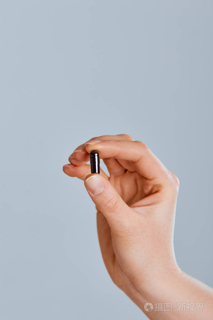 手拿黑色活性炭胶囊用于食物中毒治疗图像维生素和膳食补充剂.