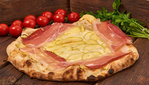 自制的新鲜美味的美味披萨，白色斑点和切片的意大利披萨，隔离在木桌上，有选择的焦点。