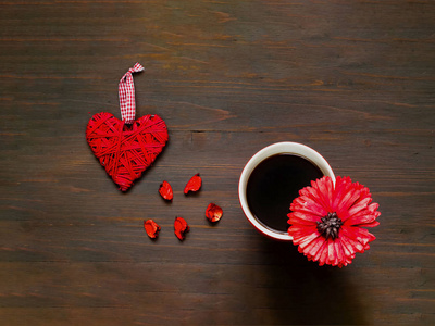爱或情人节的概念。木制背景与心脏和大红色杯子咖啡