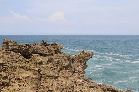 阳光明媚的印尼日惹Timang海滩上的波浪自然岩层