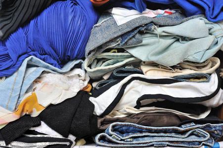 一堆乱七八糟的多色衣服在壁橱里. 杂乱无章的女人.照片