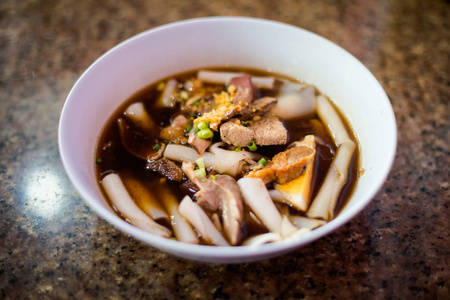 Trang当地市场上的深色酱油猪肉面条汤。 由新鲜食材制成的传统泰国菜。
