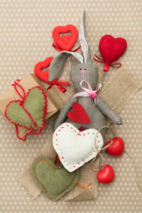 情人节。 兔子手工制作，红色和白色的心躺在纸板背景上的白色豌豆。 情人节。 心脏坠子。 文本空间。 红心。 三月八日。