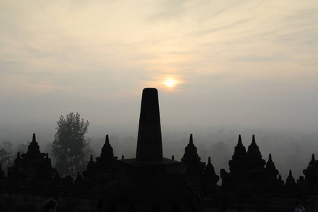 日落日日惹印度尼西亚期间环绕神秘森林的博罗布杜尔神庙剪影