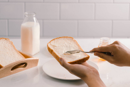人类的双手在面包片上涂黄油图片