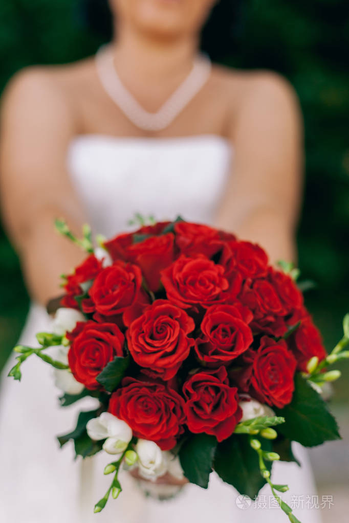 新娘女子展示一束红玫瑰花