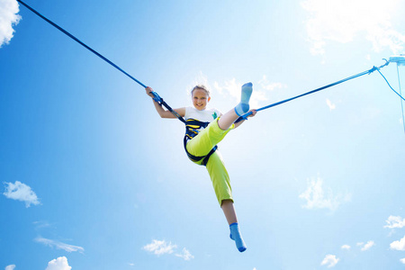 跳进水里蹦极跳上蓝蓝的天空背景上的蹦极跳的小女孩蹦极跳阿德兰亚林