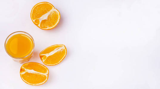 一杯橙汁和一片橙色水果在白色的背景。平躺着。复制空间