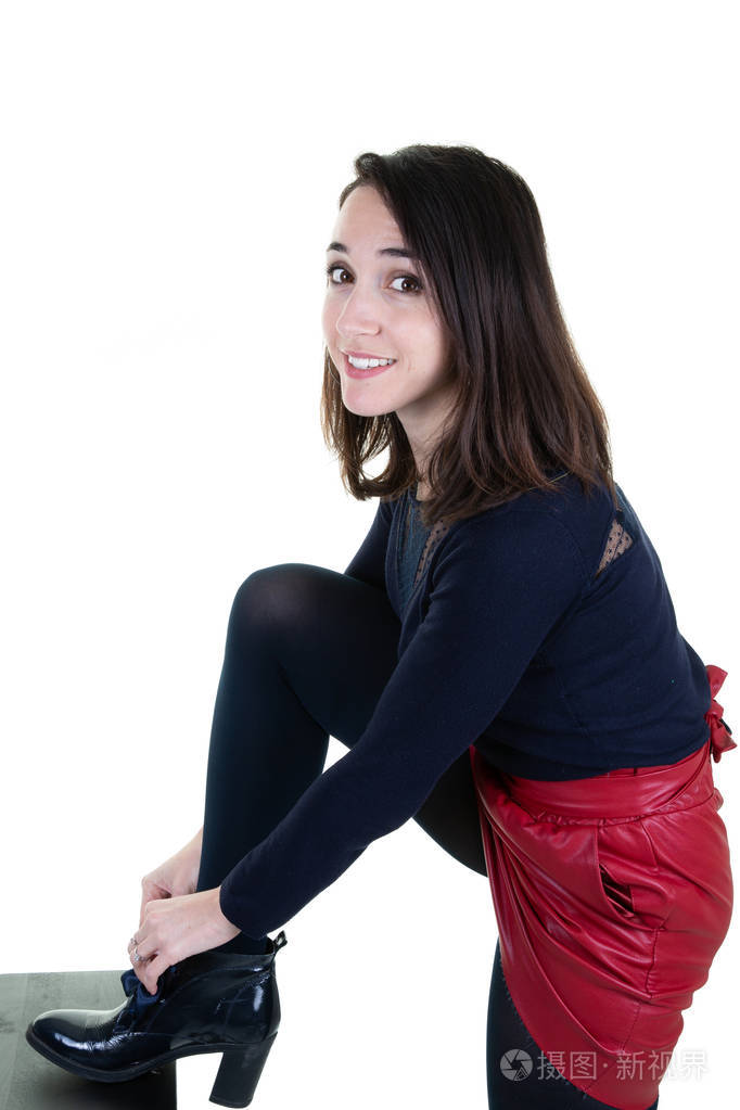 穿红裙子的年轻女子系鞋带