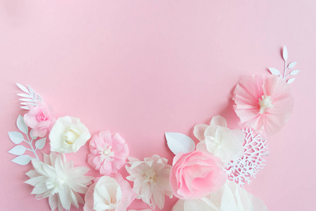 粉红色背景上的白色和粉红色纸花。花架