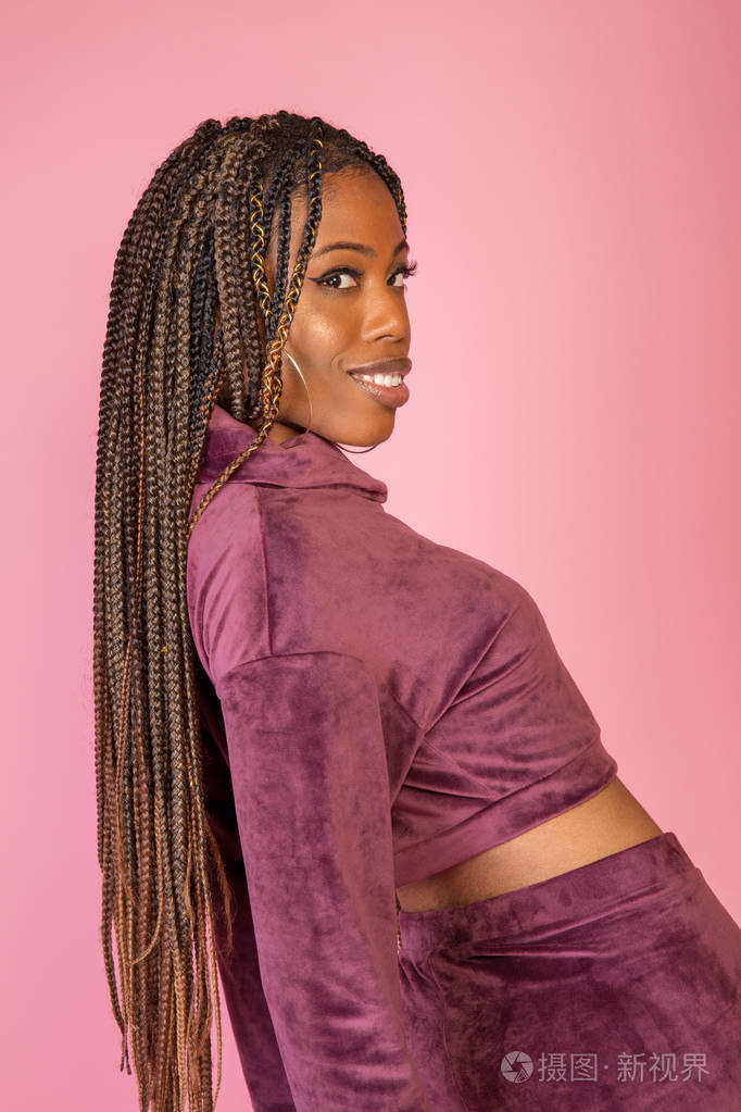 非洲裔美国妇女,有着惊人的辫子长发,穿着一套休闲的城市生活方式服装
