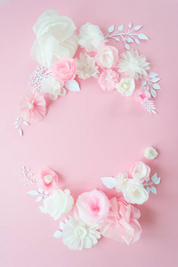 粉红色背景上的白色和粉红色纸花。 花架