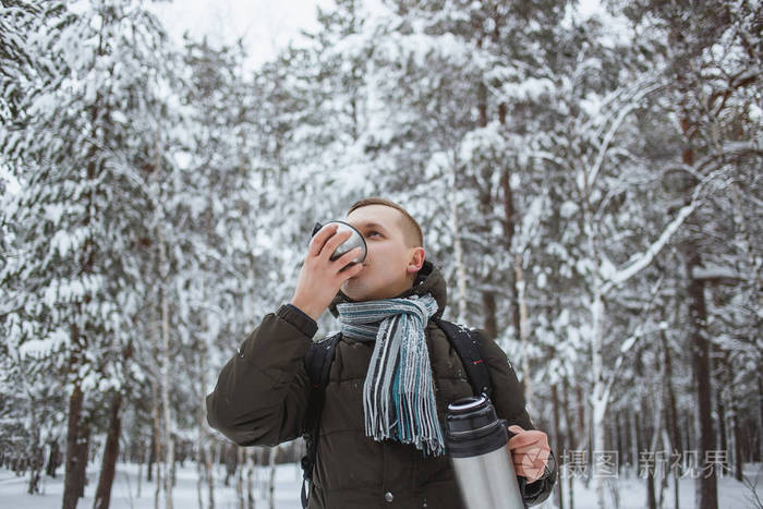 在雪针叶林里, 带着热水瓶的时尚男人