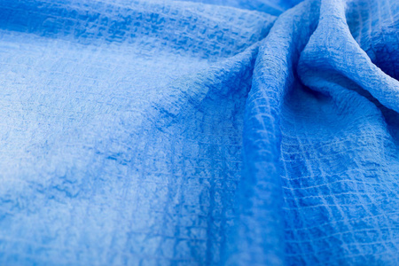 浅蓝色布一块浅蓝色的布料. 蓝色扭曲织物背景照片