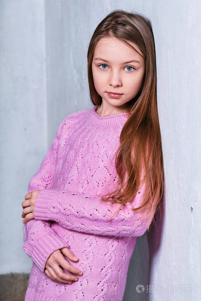 时尚模特孩子在粉红色的毛衣.肖像可爱的时尚女孩.