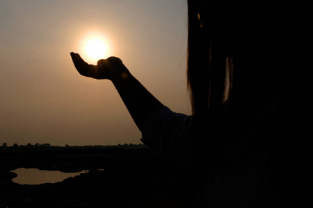 太阳在剪影女手上。