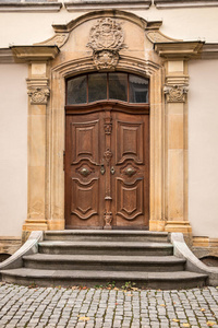 一座历史建筑的旧门，上面有用石头做成的武器