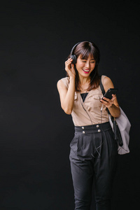一位中年上镜的中国妇女在耳机上听音乐的画像