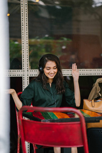 年轻的印度亚裔女性喜欢音乐，她通过耳机播放到智能手机上。