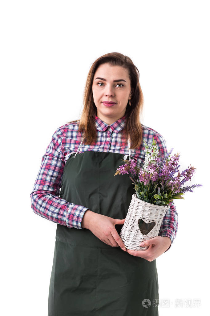 穿着围裙的女专业园丁或花匠把花放在白色背景的罐子里