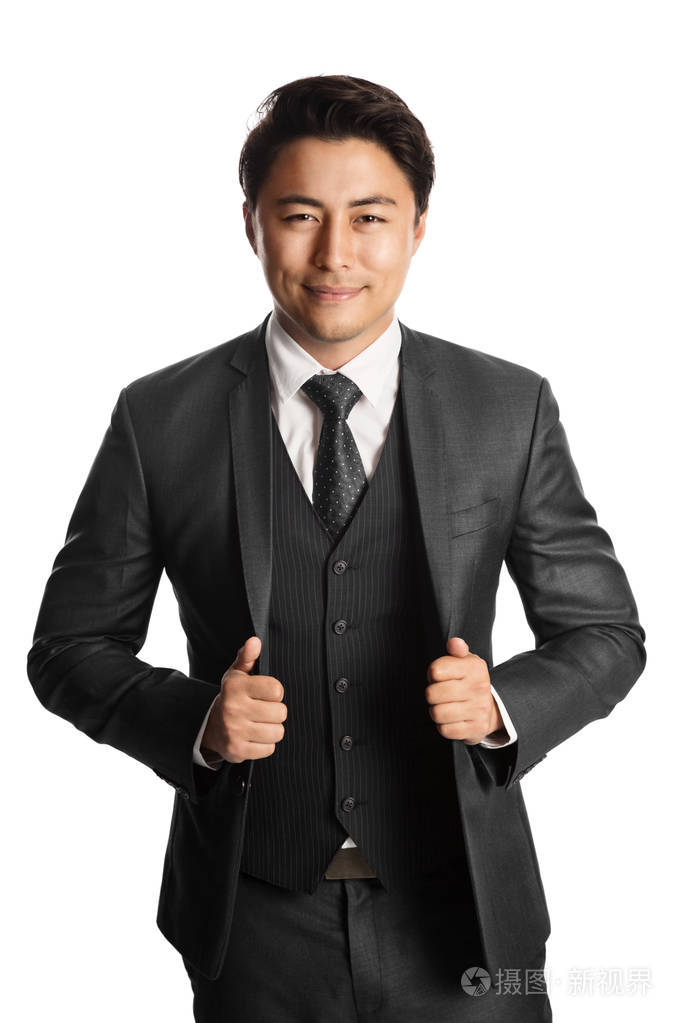 英俊的年轻企业家微笑着站在白色背景下穿着灰色西装领带和背心