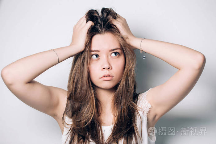 特写白色背景上美丽的年轻女子的肖像美丽的年轻女孩抬头想梦的怀疑