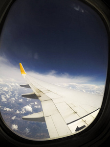 从商业飞机和飞机窗户的机翼上可以看到云。