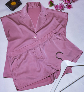 s silk pink pajamas with hanger and flowers on white background