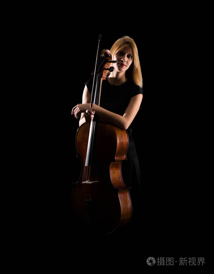 年轻女孩在孤立的黑色背景下玩大提琴