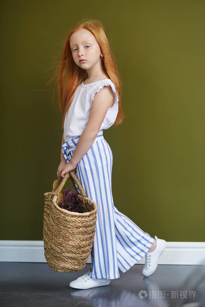 一个蓝眼睛的红头女孩的春天肖像.头发是火的颜色,挪威少女