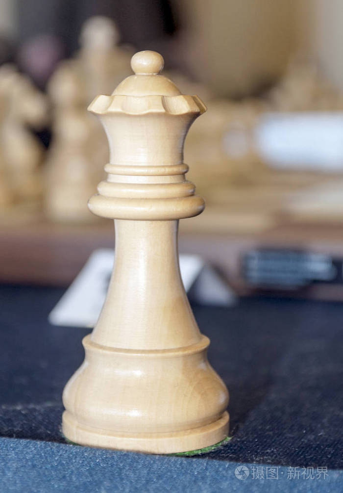白色的国际象棋女王被模糊的背景包围
