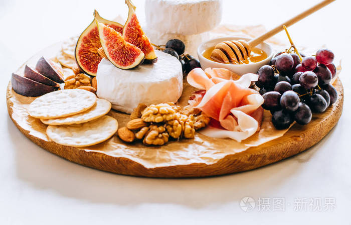 卡蒙伯特奶酪无花果果酱蜂蜜和葡萄大理石背景的芝士盘