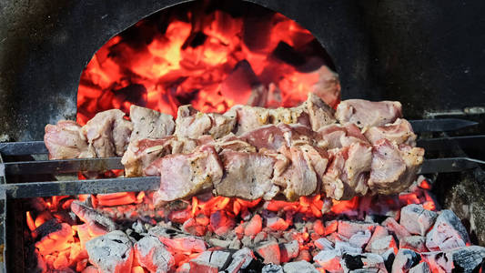 烤架上有美味的烤肉。 烧烤派对。 鸡肉肉片在木炭烤架上炸。