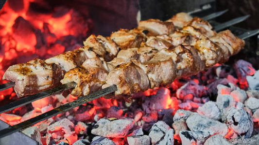 烤架上有美味的烤肉。 烧烤派对。 鸡肉肉片在木炭烤架上炸。