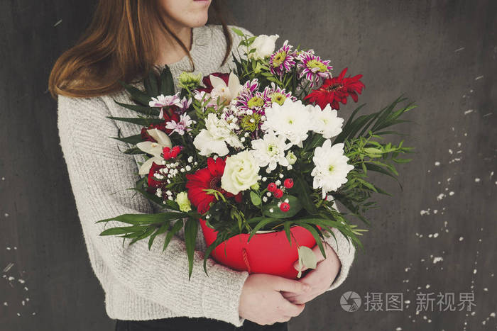 花花束在头盒年轻快乐的女人拿着一束美丽的鲜花