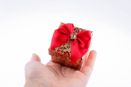 手拿一个带红丝带的礼品盒