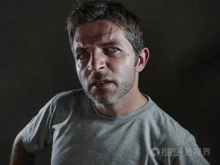 孤立的黑暗背景肖像年轻的沮丧和反抗的人傲慢和自大的姿态蔑视和好奇