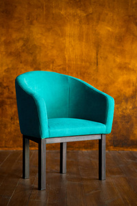 蓝色的椅子靠在一堵棕色的墙上。内部