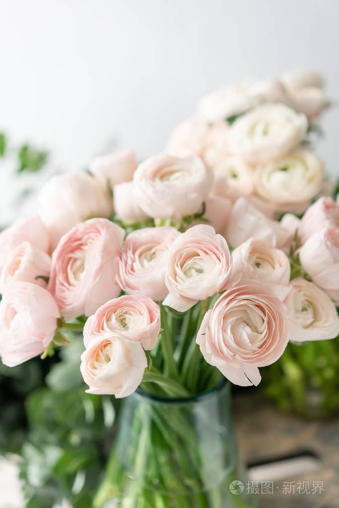 在玻璃花瓶里的波斯蝴蝶.束状淡粉色的牧场花浅色背景.壁纸.冬季花卉