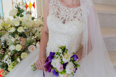 新娘穿着婚纱, 手里拿着花束