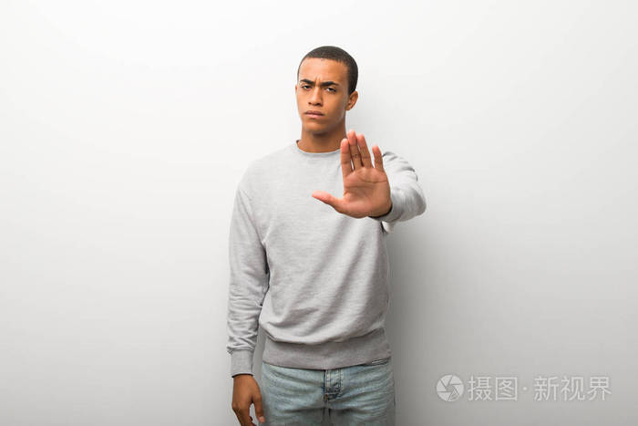 美国黑人男子在白色墙壁背景下做停止手势,否认认为错误的情况