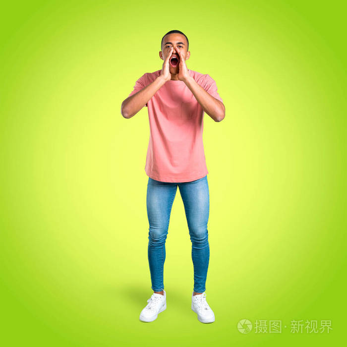 站着的年轻非裔美国人大声喊叫张开嘴向侧面喊并在五颜六色的背景上