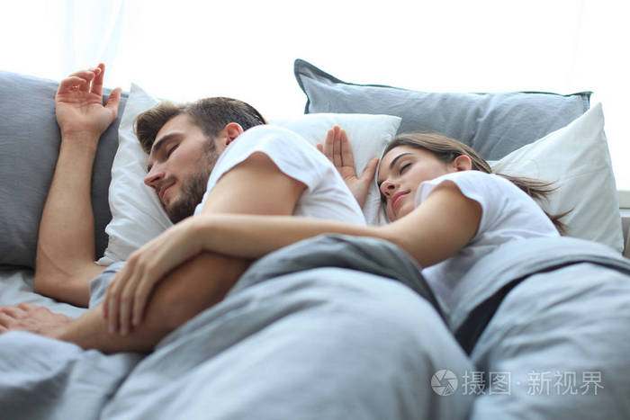 幸福的夫妇在家里舒适的床上睡觉