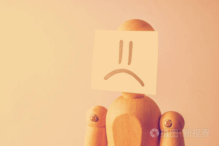 不快乐的人的概念脸木制人体模型脸上贴着一张贴纸带有悲伤的形象变调