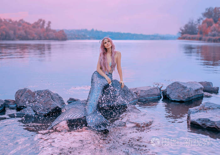 童话般的海皇后粉红色的长发水母坐在石头上梦幻般地看着紫色的天空