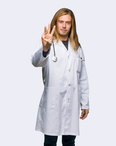 一个快乐的医生用手指在孤立的背景上数着三个